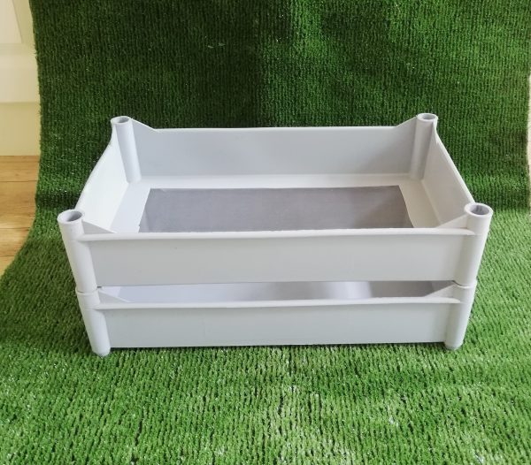 two plastic trays stacked on top of each other. The top being a mesh bottom and the bottom being solid